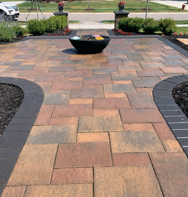Paver Patio With Black Flower Flower pot in The Middle.